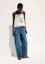 Jeans de denim azul de corte wide leg, tiro medio y diseño clásico de cinco bolsillos.