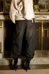 Pantalón de tiro alto con silueta slouchy, confeccionado en denim de algodón con acabado brillante y textura efecto reptil. Presenta pierna amplia que se estrecha hacia el bajo.