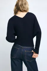 Jersey de punto color mostaza con escote en pico y manga larga con puños ajustados.
