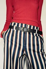 Pantalón de tiro alto y pernera recta con estampado de rayas verticales en tonos azul, marrón y beige. Incluye un cinturón delgado de color marrón oscuro con hebilla metálica dorada.
