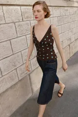 Top de tirantes finos con escote drapeado y diseño fluido. Presenta un estampado de lunares celestes sobre fondo marrón.