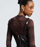 Vestido corto de poliuretano color marrón oscuro con efecto vinílico, de corte recto, escote cuadrado y tirantes finos. Cuenta con cierre de cremallera en la espalda.