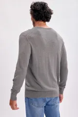 Buzo de punto con cuello redondo, manga larga y puños acanalados, de diseño clásico y ajuste estándar.