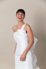Vestido largo de fiesta color blanco, confeccionado en tafeta. Diseño asimétrico con un solo bretel que se extiende en un volado de organza desde el hombro hasta la espalda.