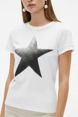 Remera negra de manga corta, con cuello redondo y ajuste al cuerpo. Cuenta con un gran estampado floral en tono gris en el frente y detalle de tachas plateadas alrededor del cuello y en los puños.
