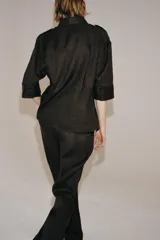 Pantalón flare de tiro medio confeccionado en lino color marrón. Cuenta con cintura con trabillas, bolsillos delanteros, perneras de corte evasé y cierre frontal con cremallera y botón.