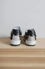 Championes de cuero color blanco con detalle de corona en animal print y talón verde. Cuentan con suela de caucho, lengüeta de gamuza y forro textil, con cierre mediante cordones al tono.