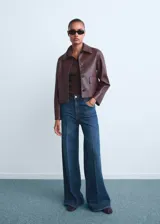 Jeans wide leg de tiro alto en color azul clásico, con diseño de cinco bolsillos, trabillas para cinturón y cierre frontal con cremallera y botón.