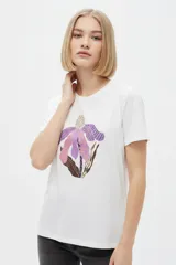 Remera de manga corta color azul marino con cuello redondo y estampado frontal de una flor en tonos celestes y blancos.