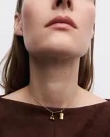 Aros colgantes con forma de cerezas doradas, con un pequeño cristal incrustado en una de ellas.