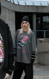 Remera de algodón color gris oscuro con efecto lavado, de corte holgado y manga corta. Presenta una estampa frontal detallada que muestra una serpiente entrelazada alrededor de una paleta de madera con corazones, rodeada por un diseño de alambre de púas.