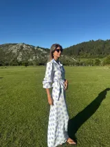 Camisa blanca con lunares celestes, de corte clásico, con cuello camisero y mangas largas abullonadas.