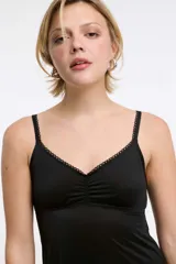 Camisón negro de microfibra, con tirantes finos regulables, escote corazón con detalle de encaje y frunce frontal, y falda corta fluida.