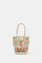 Bolso de mano de formato tipo bucket en color crudo, completamente revestido con abalorios y bordado con motivos florales multicolores en tonos rosados, verdes y celestes. Cuenta con doble asa corta de mano y cierre con botón imantado.