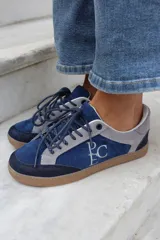 Championes de estilo urbano en combinación de tonos marrones y crema, confeccionados en gamuza y cuero. Presentan cordones jaspeados, suela de goma y detalle de logo bordado en el lateral.
