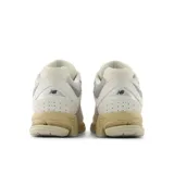 Championes New Balance modelo 2002R, color crema con detalles en gris y beige.