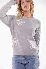Sweater gris de punto con cuello redondo y flores blancas bordadas.