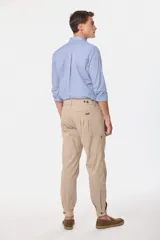 Pantalón de vestir color verde oliva, de corte recto, con bolsillos laterales y traseros. Se ajusta a la cintura con cinturón de cuero marrón.