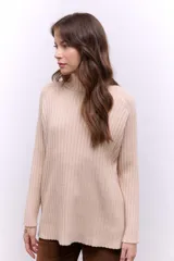 Polera de tejido de punto acanalado en color negro, con cuello alto y diseño de corte recto con largo asimétrico, más corto adelante y más largo atrás.