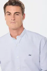 Camisa celeste a rayas verticales, de corte clásico, con cuello mao y manga larga.