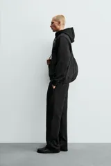 Pantalón jogger de corte regular fit y color negro, confeccionado en tejido compacto de algodón con interior de rizo. Cuenta con cintura elástica, bolsillos frontales y un bolsillo trasero de doble vivo.