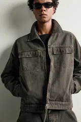 Cazadora relaxed fit de algodón con diseño de rayas, cuello solapa y cierre frontal de cremallera. Cuenta con bolsillos de solapa en el pecho y manga larga con puños abotonados.
