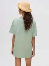 Remera verde agua con cuello redondo y manga corta, con un pequeño estampado de una estrella en el pecho. Corte holgado y cuadrado.