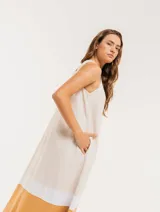 Vestido largo color blanco con franjas horizontales en amarillo y beige, de lino, con escote en V y bolsillos laterales.