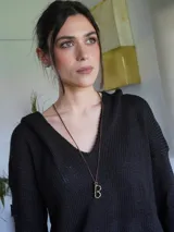 Collar con dije de letra "B" dorada, con cadena de tiento marrón.