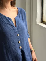 Blusa azul marino de lino, con escote en V y botones frontales de madera.