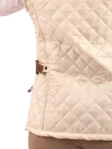 Chaleco capitoneado color rosa claro, con cuello alto, cierre frontal con botones a presión y logo bordado en el pecho.