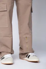 Pantalón tipo carpintero de corte relaxed fit y tiro medio, confeccionado en denim negro con costuras a contracolor en blanco. Presenta múltiples bolsillos cargo laterales, un bolsillo con cierre en la parte inferior y presillas utilitarias.