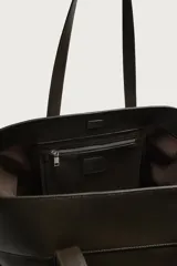 Bolso tipo shopper de piel marrón oscuro, con doble asa de hombro y cierre magnético en el compartimento principal.
