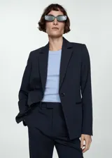 Blazer de corte entallado y diseño recto, con solapas con muesca, hombros estructurados y cierre frontal de un botón. Cuenta con dos bolsillos de ribete delanteros, abertura posterior y forro interior.