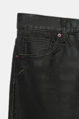 Jeans de tiro bajo y corte recto holgado, con efecto encerado en color negro, cinco bolsillos y trabillas para cinturón. Cierre frontal con cremallera y botón metálico.