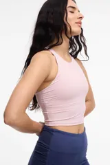 Top deportivo color crema, con espalda baja y copas removibles.