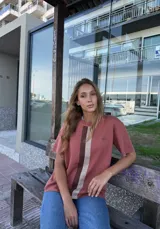 Buzo de hilo color ladrillo con rayas verticales en beige y marrón.