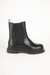 Bota Chelsea de cuero sintético color negro, con elástico lateral y aplique metálico dorado en la puntera.