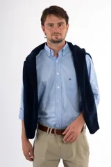 Camisa blanca de vestir, corte clásico, con cuello abotonado y bolsillo en el pecho.