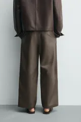 Pantalón de corte balloon fit confeccionado en piel, con bolsillos delanteros y traseros de vivo, cierre frontal con cremallera y botón.
