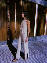 Blusa de punto color beige con lurex, modelo halter y diseño acanalado.