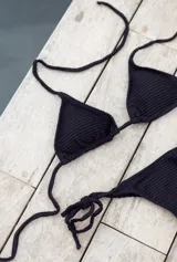 Bikini color terracota con brillo sutil. El corpiño es de triángulos movibles con almohadillas desmontables, para atar al cuello y espalda. La bombacha es colaless, para atar en los laterales.