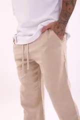 Pantalón de vestir color verde militar, de corte recto y tiro medio, con bolsillos laterales y cordón ajustable en la cintura.