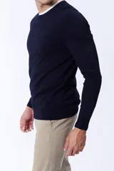 Buzo de punto con cuello redondo a la base, de manga larga y corte clásico, confeccionado en tejido de punto fino.