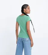 Remera básica de algodón color verde claro con escote en V, manga corta y un pequeño bolsillo frontal en el pecho.