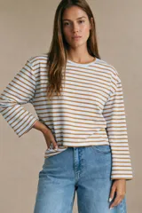 Remera de manga larga con diseño de rayas horizontales en color tostado y blanco. Presenta un corte holgado y cuello redondo.