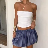 Pollera globo de corte corto, con diseño abullonado y estampado de rayas verticales azules y blancas, con elástico en la cintura.
