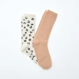 Pack de dos pares de medias de textura suave y afelpada. Un par es de color beige liso y el otro es de color crema con estampado de leopardo.