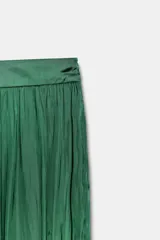 Pantalón de tiro medio confeccionado en tejido satinado verde, con diseño bombacho y bajos acabados en puño elástico. Cuenta con cierre lateral con cremallera oculta en costura.