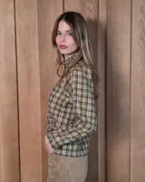 Camisa de algodón con estampado de rayas verticales finas, cuello alto con volados, cierre frontal con botones dobles y mangas largas con puños elásticos terminados en volados.